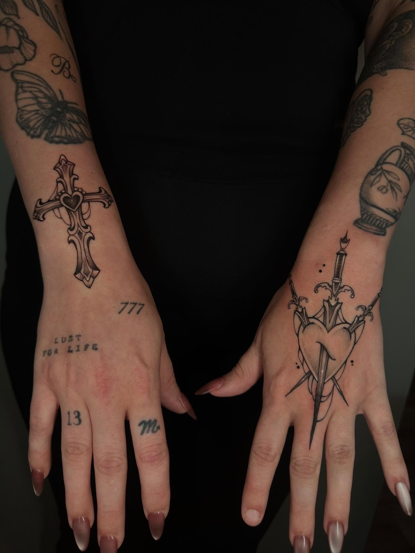 Tatuagens nas mãos — cruz e adaga — Gio Souza