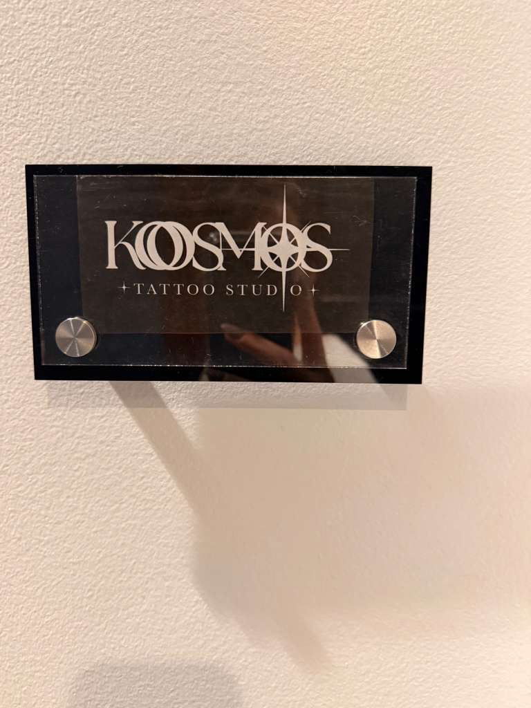 Placa do Kosmos Tattoo Studio — estúdio próprio de Gio Souza